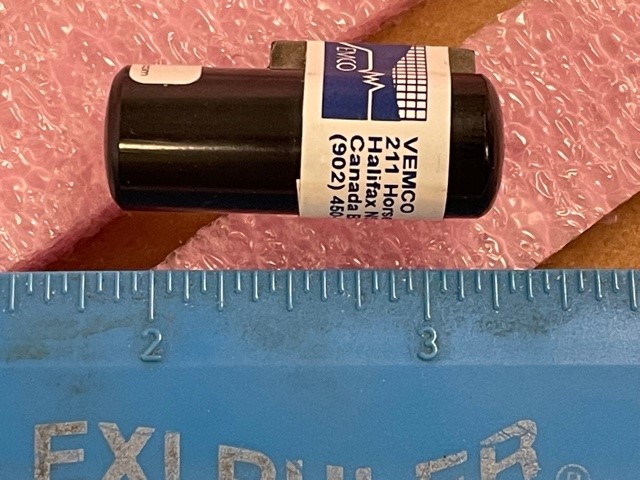 A ruler measuring a modern acoustic receiver, which is about 1 inch in length. 