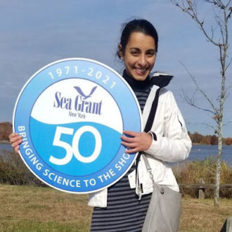 lilli genovesi of new york sea grant holding a sign celebrating sea grant's 50th anniversary