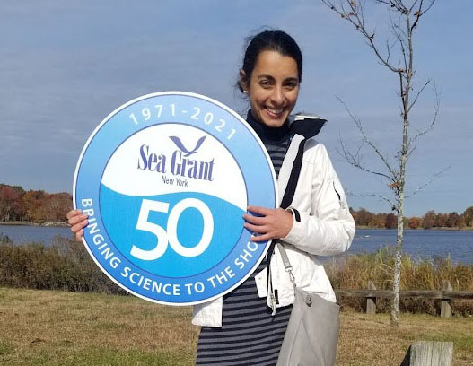 Lilli Genovesi with a sign celebrating New York Sea Grant's 50th anniversary in 2001.
