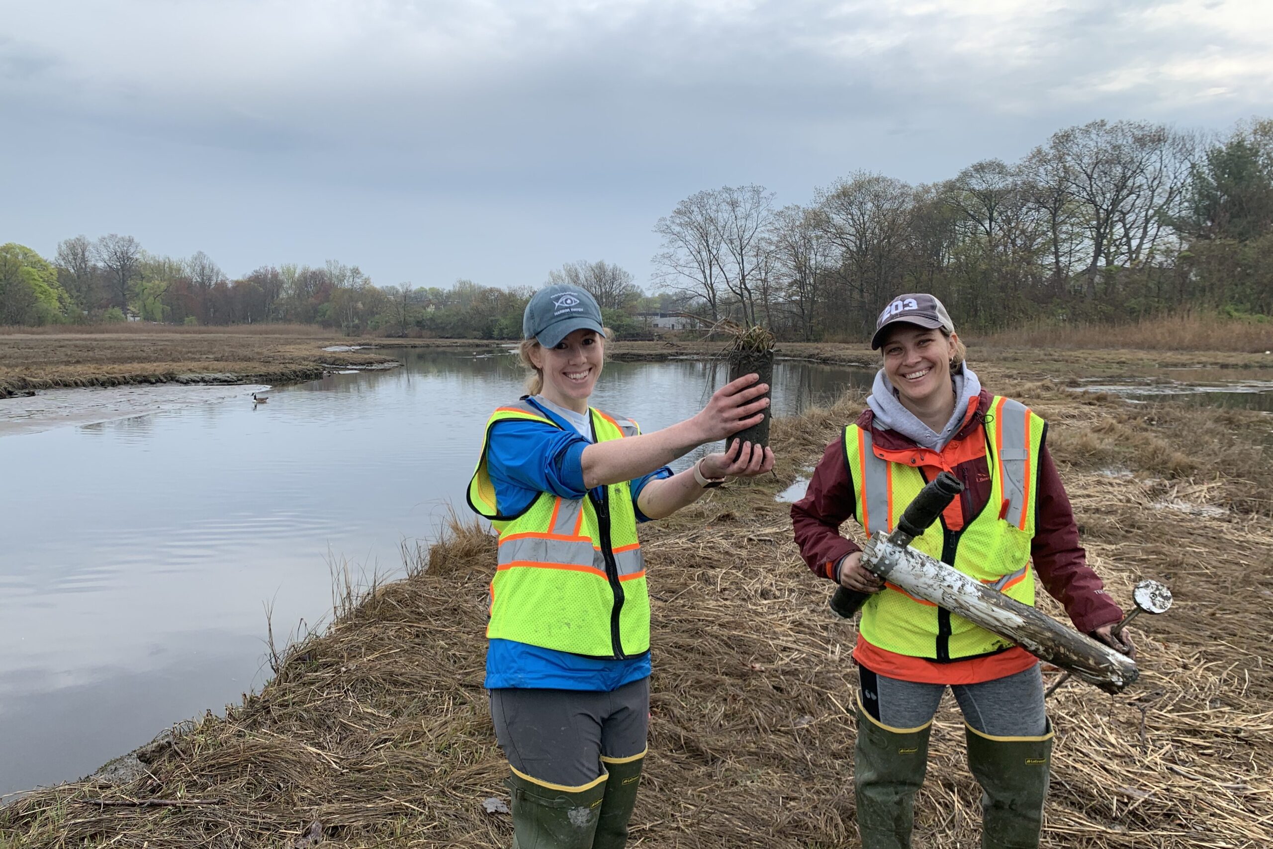 Sarah Crosby, pictured on the left, holds  a plant and dirt. 
