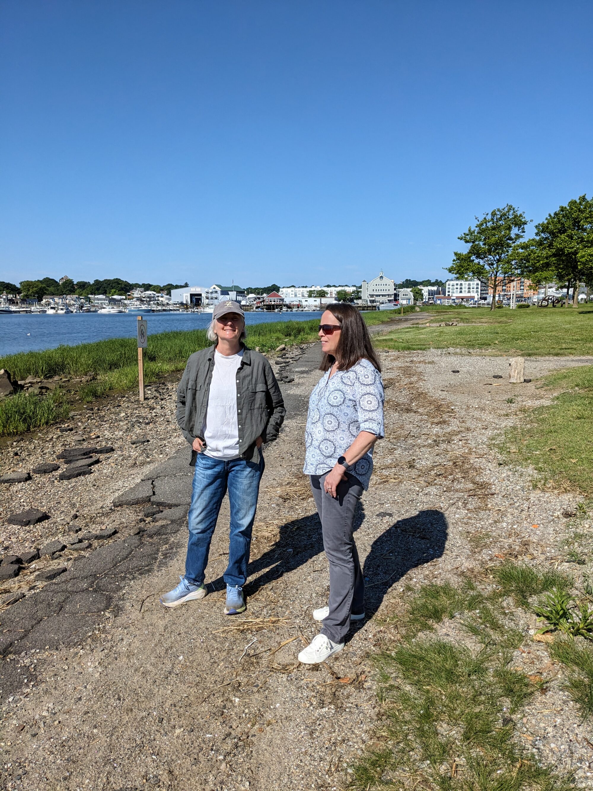 Two people talk by the water.