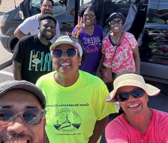 A group of people smile next to a van.