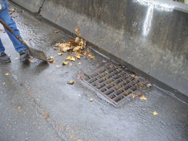 A man clears a drain. 