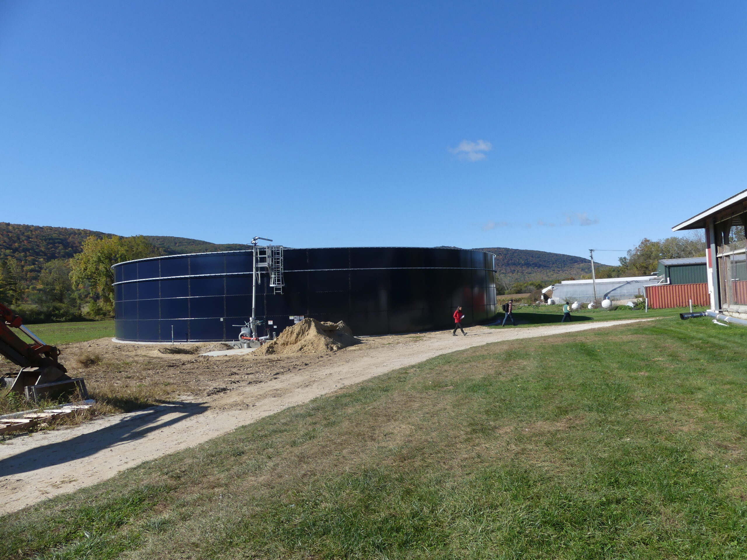 A large black manure storage structure on a farm.